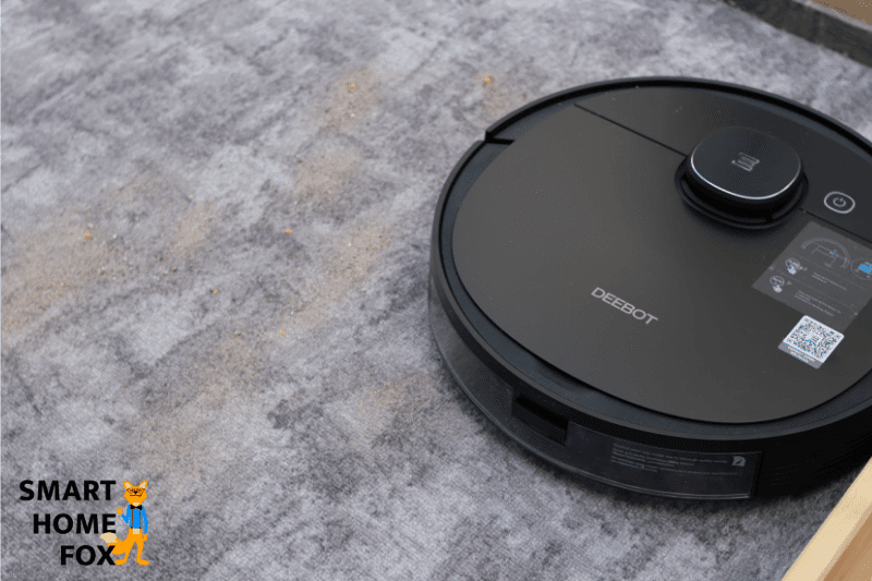 Deebot OZMO 950 во время испытания на всасывание песка на ковре с коротким ворсом.